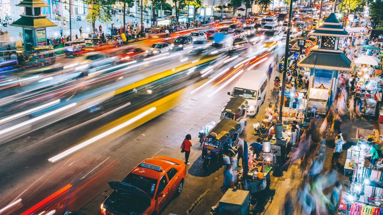 Vue animée d'une route avec voitures et passants